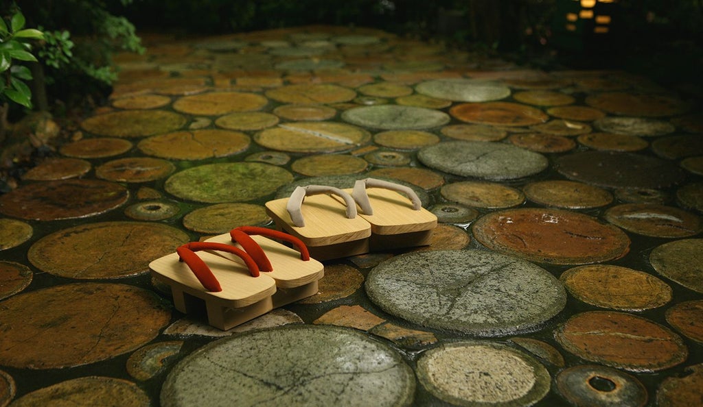 Minimalist traditional Japanese ryokan with wooden architecture, elegant tatami rooms, and serene garden nestled in lush mountainous landscape at scenic origin.