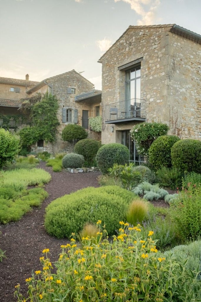 Elegant stone farmhouse with lavender fields, restored historic hotel nestled in Provençal countryside, soft natural light and rustic architectural charm