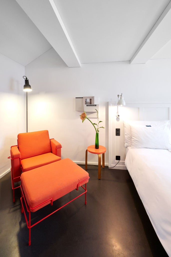 Elegant double room with Swiss-style minimalist design, soft neutral tones, hardwood floors, and modern light fixtures in boutique Scenset hotel