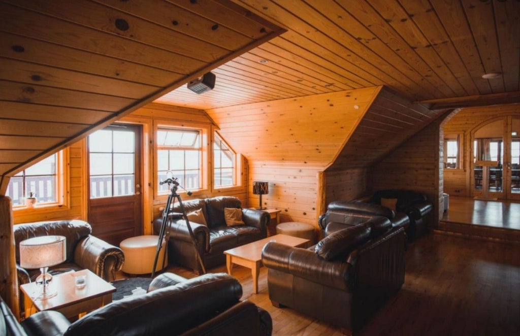 Luxurious wooden Hotel Rangá nestled in snowy Icelandic landscape, featuring rustic log cabin architecture and warm glowing windows