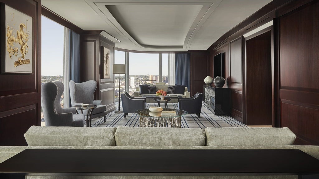 Spacious presidential suite with panoramic city views, elegant contemporary furnishings, plush king bed, marble bathroom, and sophisticated Boston skyline backdrop