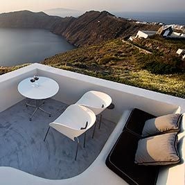 Luxurious white-washed Greek resort nestled on a cliff overlooking the azure Aegean Sea with elegant infinity pool and traditional Cycladic architecture