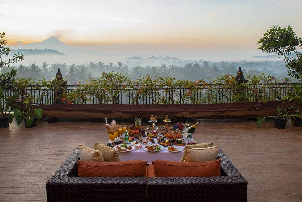 Luxurious infinity pool overlooking lush jungle and ancient temples, with Mount Merapi volcano visible in misty mountain backdrop