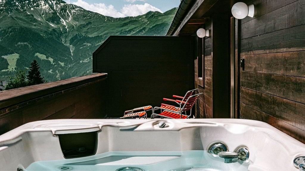 Panoramic mountain view from a luxurious chalet suite in Swiss Alps, featuring minimalist design with floor-to-ceiling windows and elegant wooden furnishings