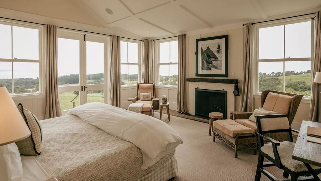 Elegant two-bedroom suite with panoramic bay views, featuring plush king beds, modern wood furnishings and sophisticated neutral decor