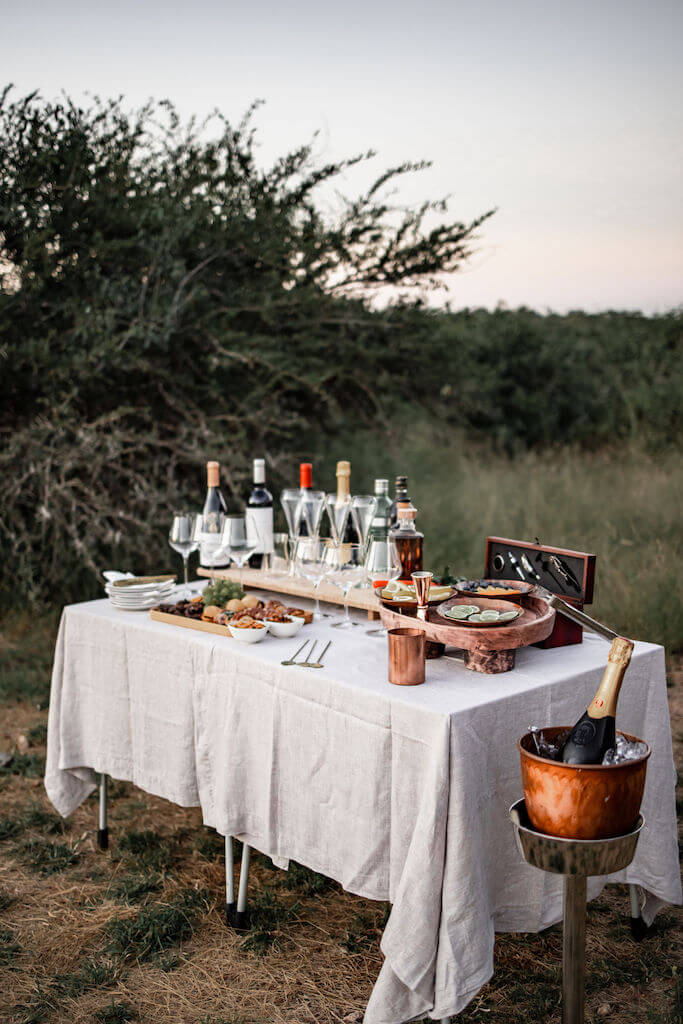 Luxurious glass-walled hotel suite perched on historic railway bridge over Sabie River, offering panoramic views of Kruger National Park