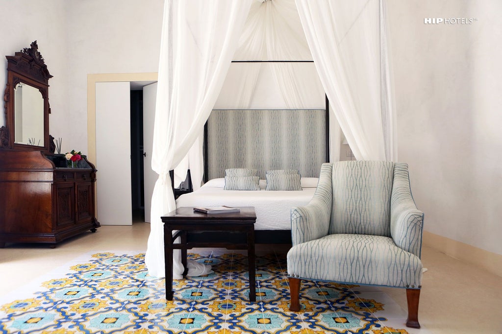 Elegant Italian hotel room with soft neutral tones, luxurious white linens, antique wooden furniture, and large window overlooking Sicilian landscape