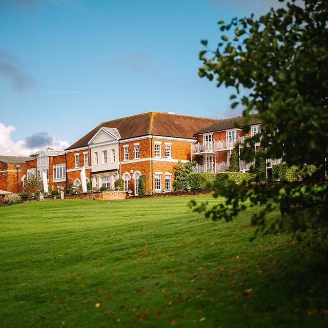 Luxurious countryside hotel nestled in lush New Forest landscape, featuring elegant stone exterior, manicured gardens, and sophisticated architectural design