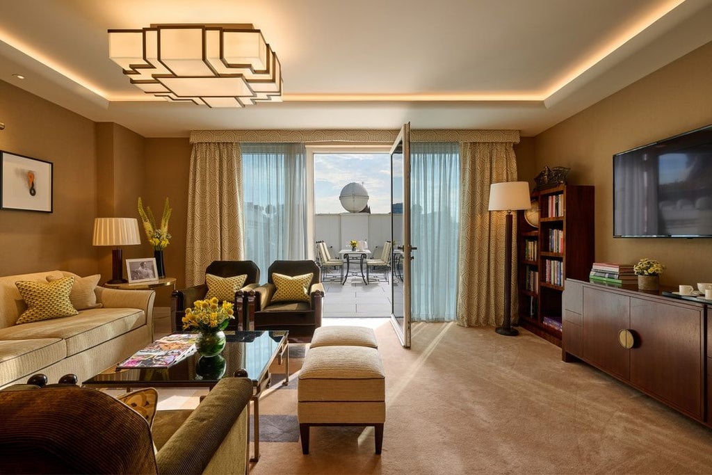 Elegant classic suite at luxury hotel with plush king bed, cream marble bathroom, soft neutral tones, and sophisticated contemporary design details