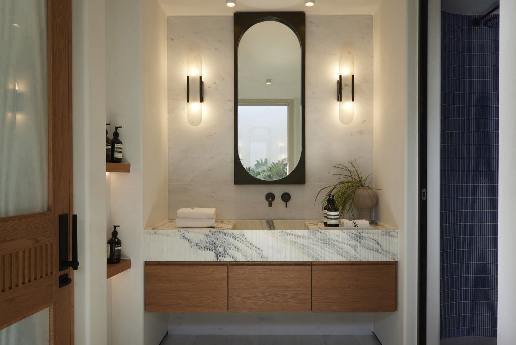 Modern coastal suite with private plunge pool, glass balcony railings, and side ocean views, featuring minimalist white furnishings