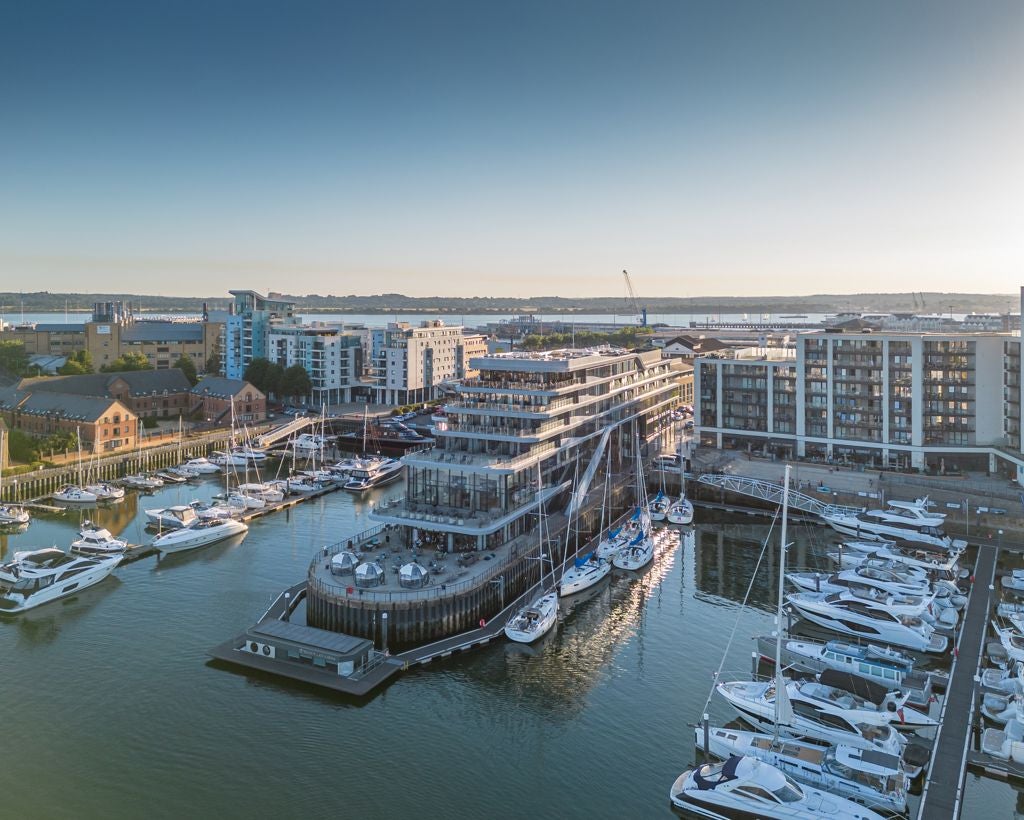 Luxurious waterfront hotel with modern glass facade, overlooking Southampton harbour, sleek architecture and elegant design reflecting maritime elegance