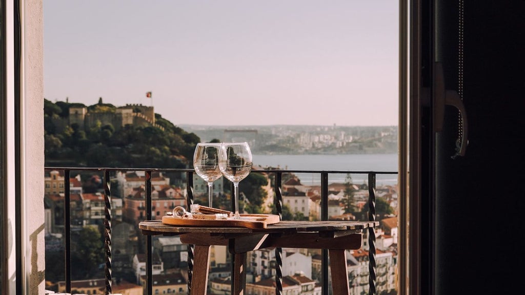 Sunset panorama of Lisbon's historic district with terracotta rooftops, ornate church towers and golden light reflecting on the Tagus River