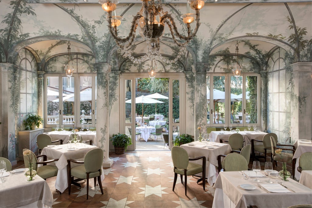 Elegant stone facade of Hotel De Russie in Rome with ornate balconies, manicured greenery, and classic Italian Renaissance architecture