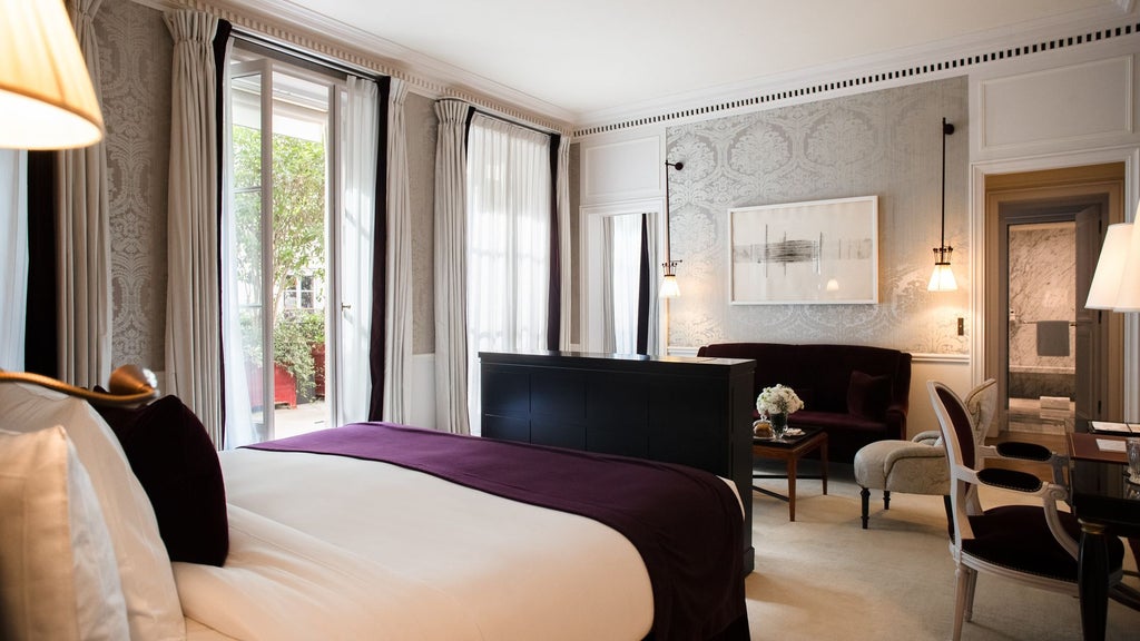 Elegant Parisian junior suite with private terrace, featuring modern furnishings, soft neutral tones, and panoramic city views at La Réserve luxury hotel