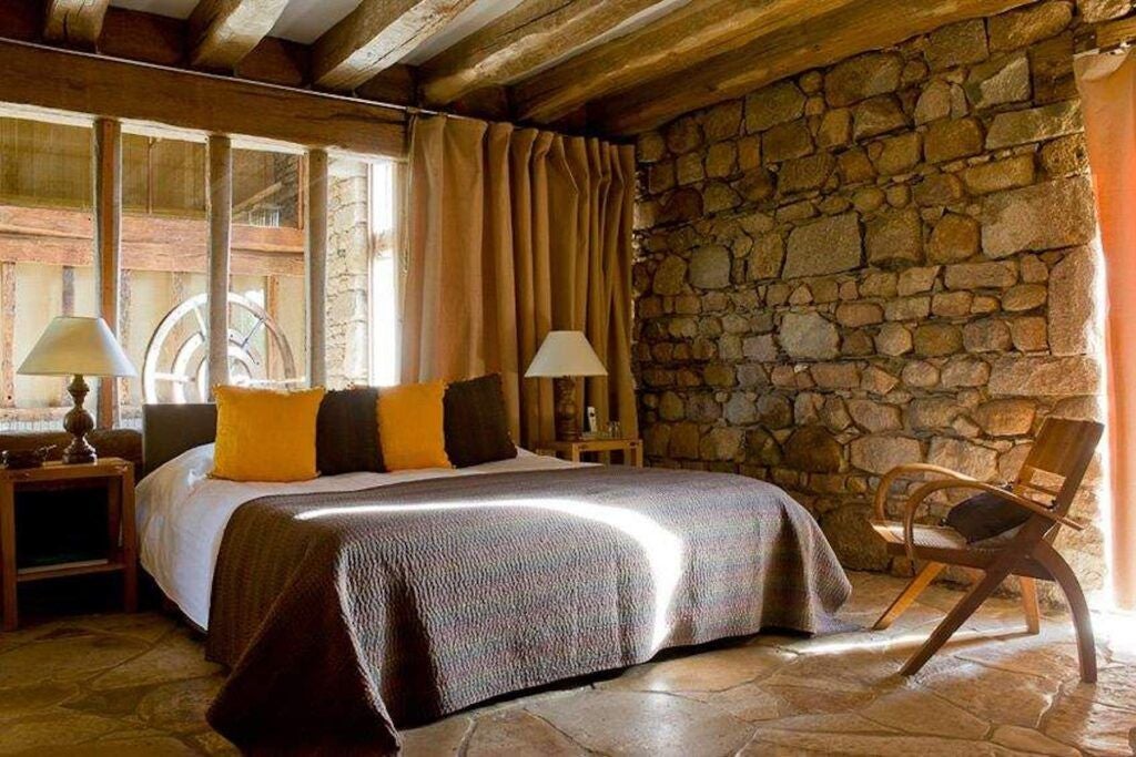 Luxurious French cottage bedroom at Domaine des Etangs, featuring elegant wooden furnishings, soft natural light, and rustic-chic design elements