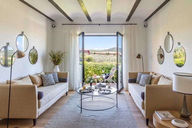 Rustic Italian boutique hotel room with warm terracotta walls, elegant wooden furnishings, and soft natural lighting in a Tuscan-inspired design