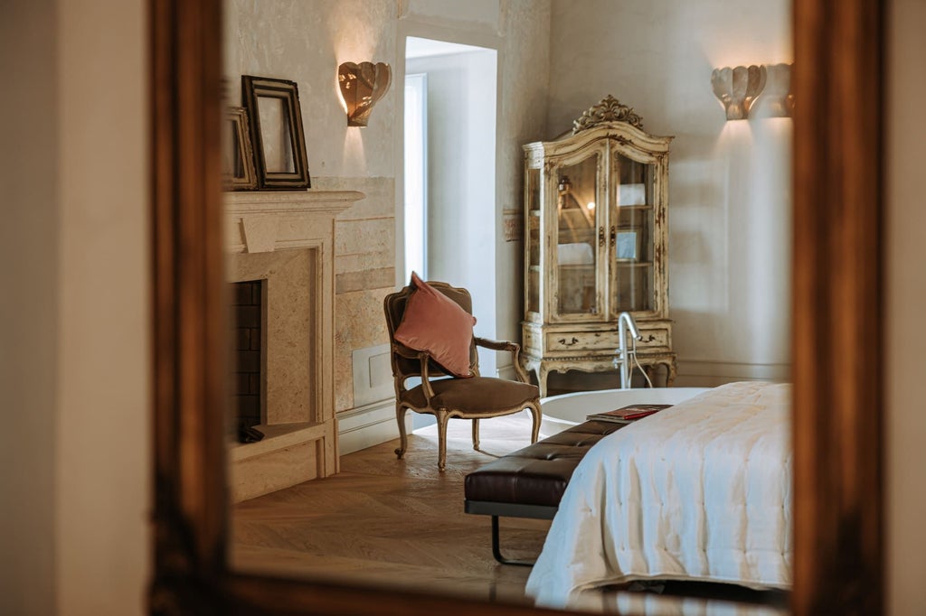 Spacious Italian luxury suite with elegant white and blue decor, marble bathroom, king-sized bed, and panoramic windows overlooking scenic landscape in Puglia