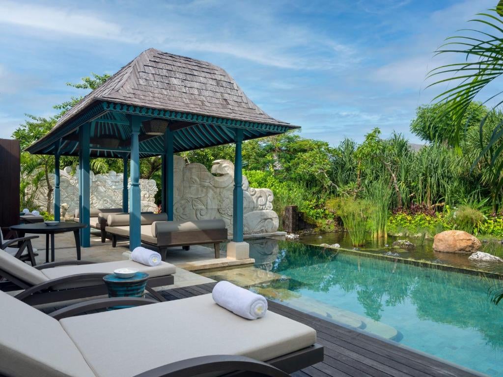 Oceanfront infinity pool with floating sun loungers at luxury Jumeirah Bali resort, overlooking the Indian Ocean and tropical gardens