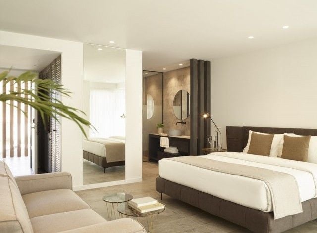 Luxurious deluxe suite at Lango Design Hotel & Spa, featuring modern minimalist decor, expansive sea view, and elegant shared pool in a Greek island setting