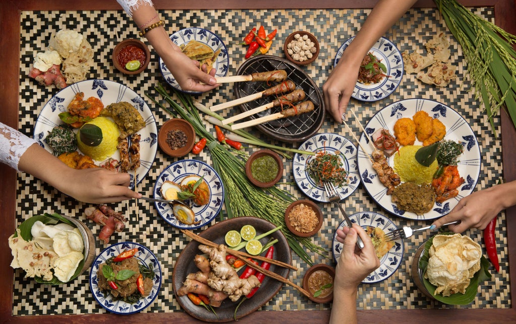 Elegant couple enjoying intimate Balinese cooking class amid lush tropical gardens, preparing traditional dishes with fresh local ingredients at sunset