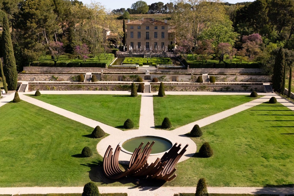 Elegant stone château with manicured gardens, overlooking Provençal landscape, showcasing luxurious French countryside estate with soft golden sunlight