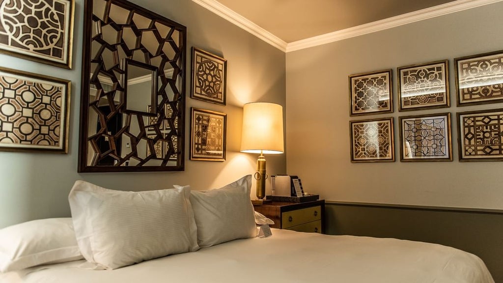 Elegant art deco hotel façade with ornate stone detailing, bronze accents, and rounded balconies overlooking Santiago's historic Lastarria district