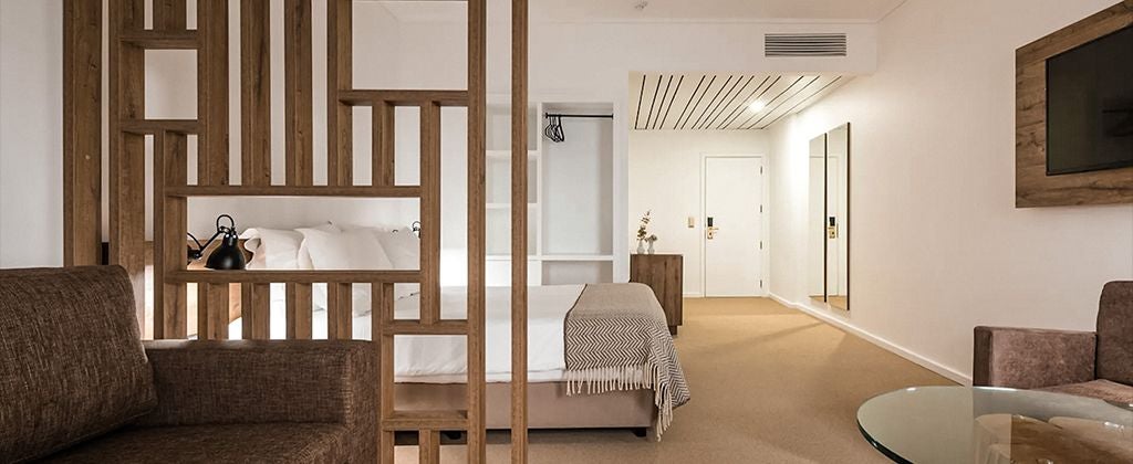 Luxurious superior hotel room with panoramic valley view, elegant contemporary decor, plush white bedding, and warm wooden accents in Lamego, Portugal