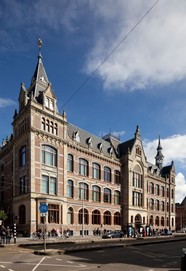 Luxurious glass and steel facade of Scenset Conservatorium Hotel in Amsterdam, blending historic architecture with modern design elegance