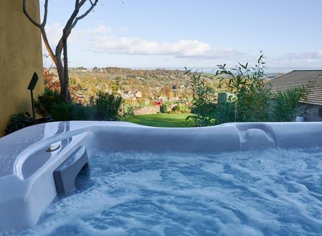 Luxurious Mews Hot Tub Suite at Homewood Hotel & Spa, featuring elegant bedroom with modern design and private hot tub, United Kingdom.