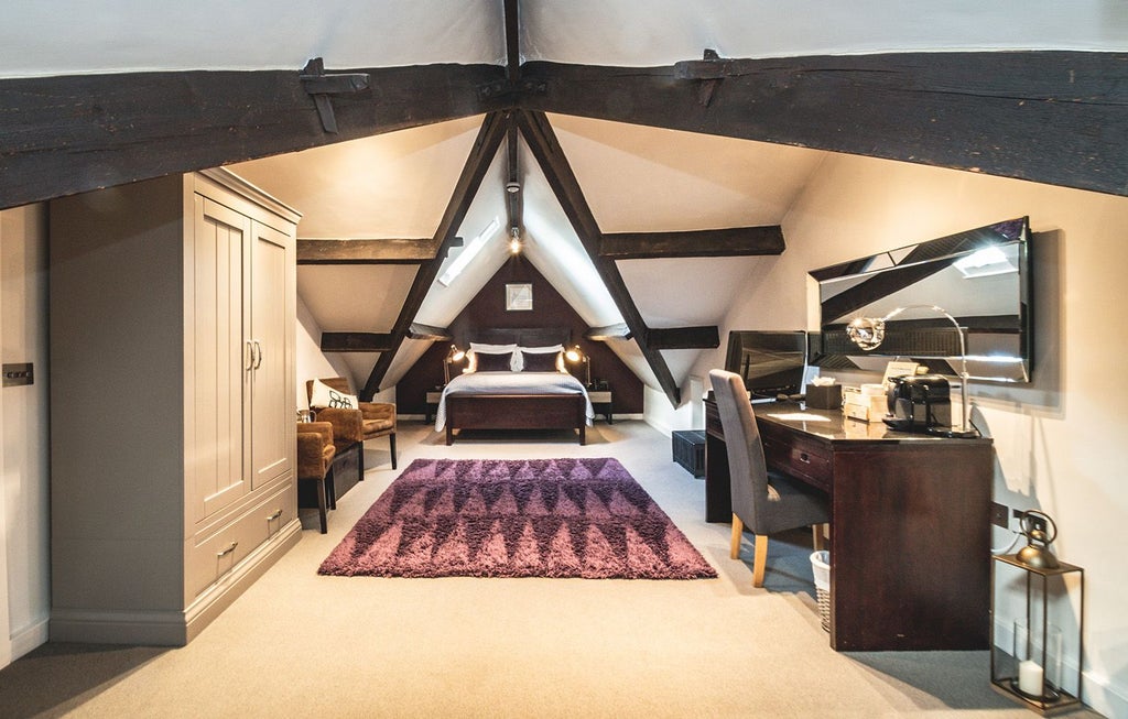 Luxurious loft suite with contemporary design, featuring high ceilings, plush bedding, and elegant modern furnishings in a spacious UK hotel room setting