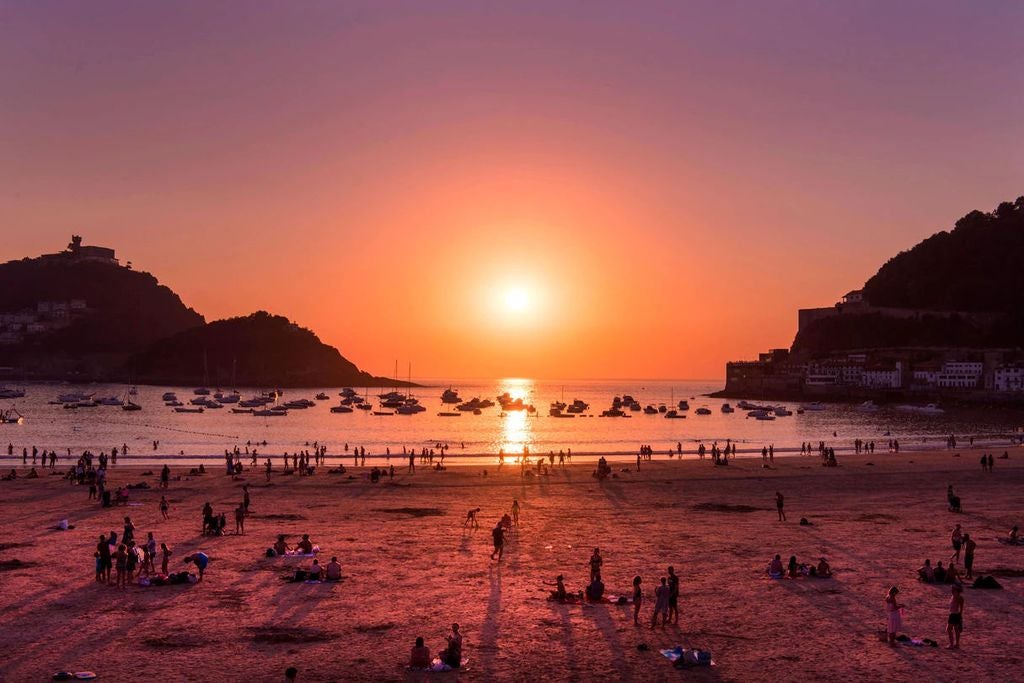 Scenic Basque Country coastal town with colorful traditional buildings nestled between green hillsides and blue Bay of Biscay waters