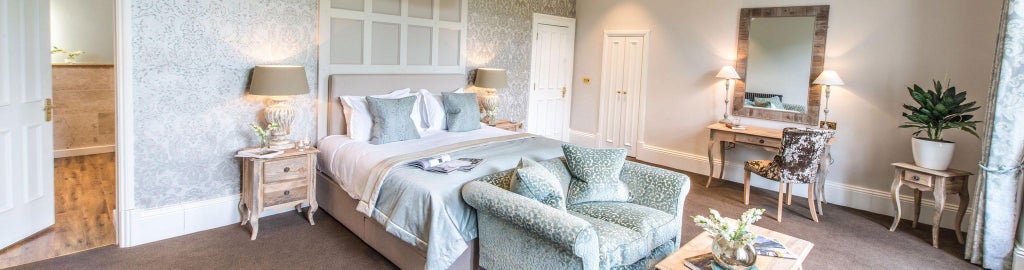 Luxurious master bedroom at Forest Side hotel with elegant dark wood furnishings, soft ambient lighting, and plush bedding in a serene woodland-inspired setting