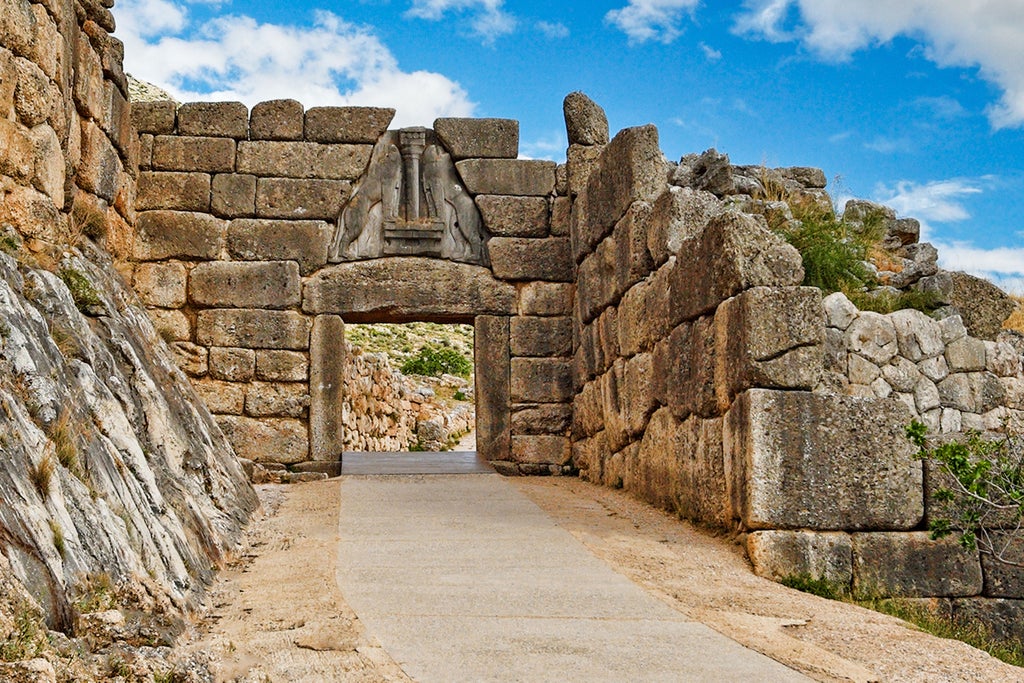 Ancient stone walls of Mycenae archaeological site, luxurious private guided tour with expert historian near legendary Lion Gate under golden Mediterranean sunlight