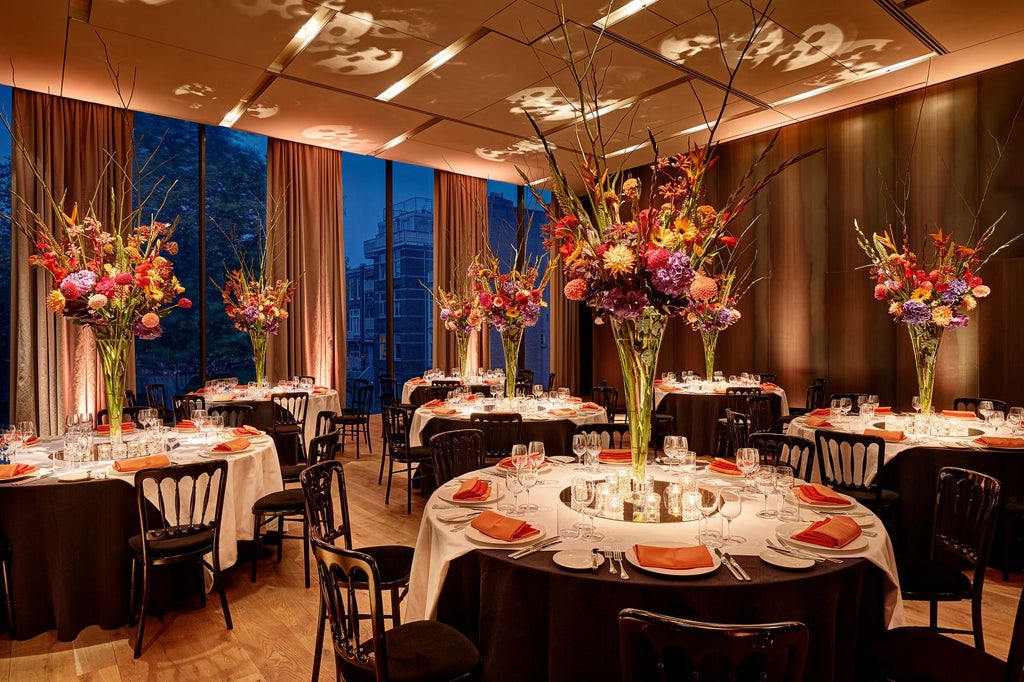 Luxurious glass-fronted Conservatorium Hotel in Amsterdam, with modern architectural design blending historic building and contemporary glass structure.