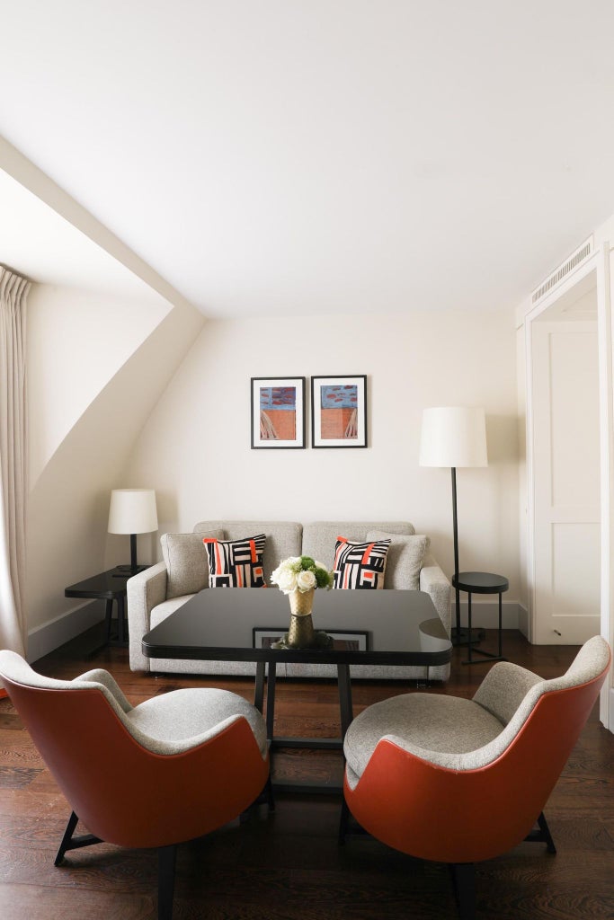 Elegant junior suite at Hotel Montalembert in Paris, featuring plush white bedding, contemporary French design, and soft neutral color palette