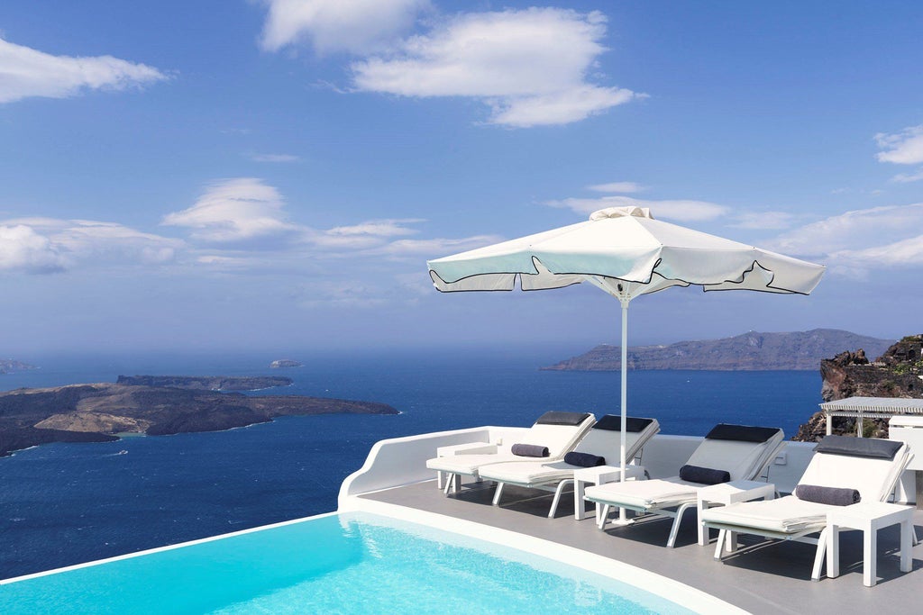 Luxurious white-washed Cycladic hotel perched on Santorini's cliffside, overlooking the azure Aegean Sea with elegant infinity pools and pristine architectural design