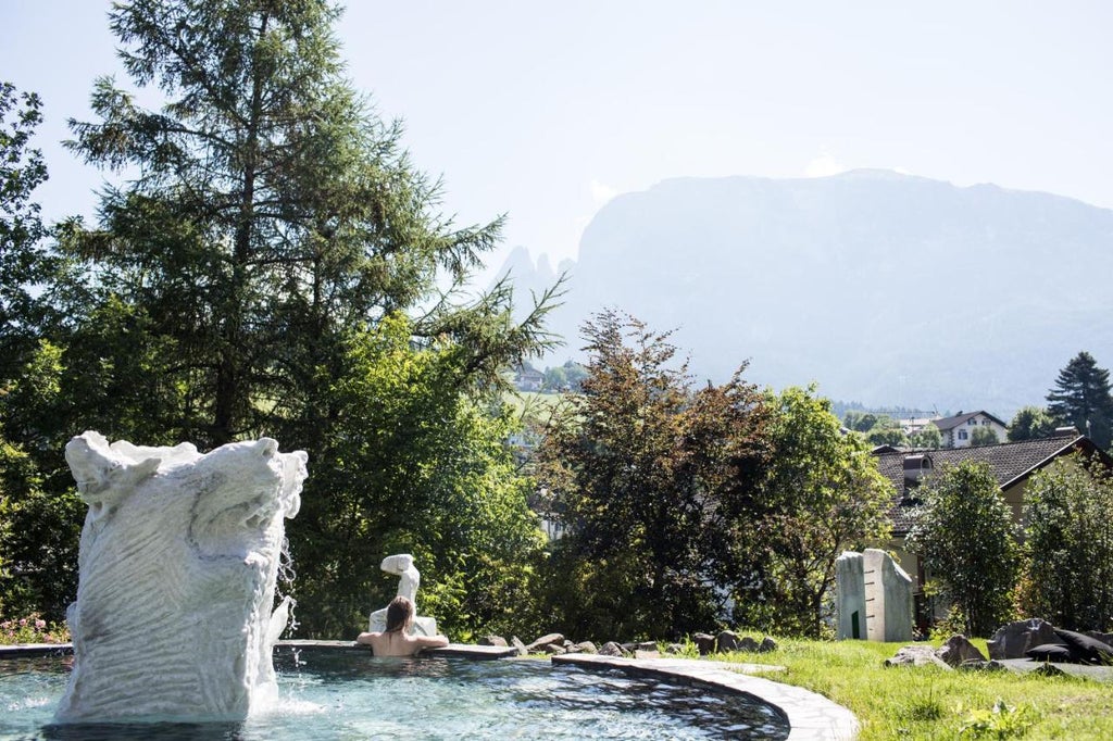 Stone castle hotel with medieval tower nestled in Italian Dolomites mountains, featuring rustic architecture and panoramic views at sunset