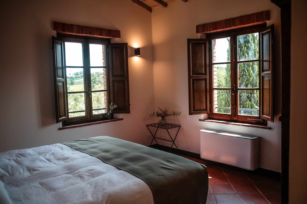 Elegant Tuscan boutique hotel with stone facade, arched windows, and flowering plants set against warm evening sunlight in pastoral setting