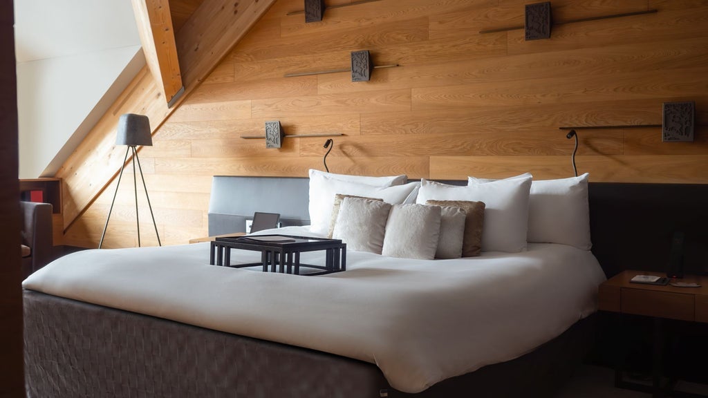 Luxurious alpine suite with modern Swiss design, featuring panoramic mountain views, elegant wood paneling, and contemporary minimalist furnishings