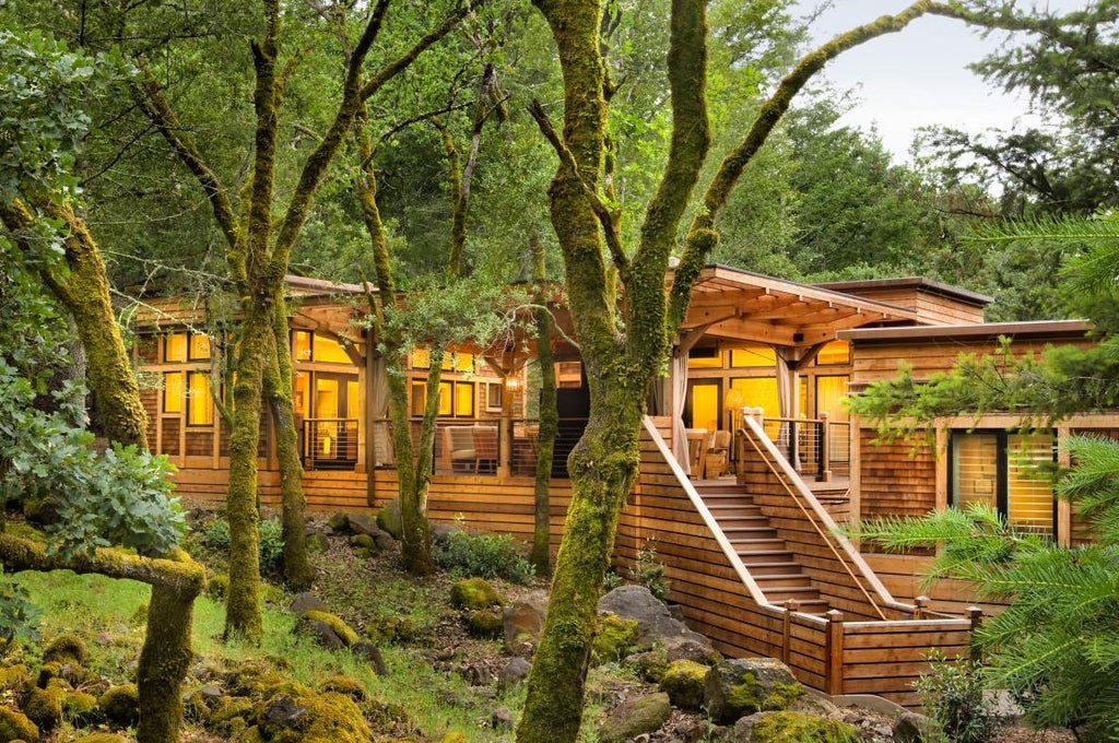 Luxurious wooden cabin resort nestled in California wine country with private terrace, natural stone accents and forest canopy views