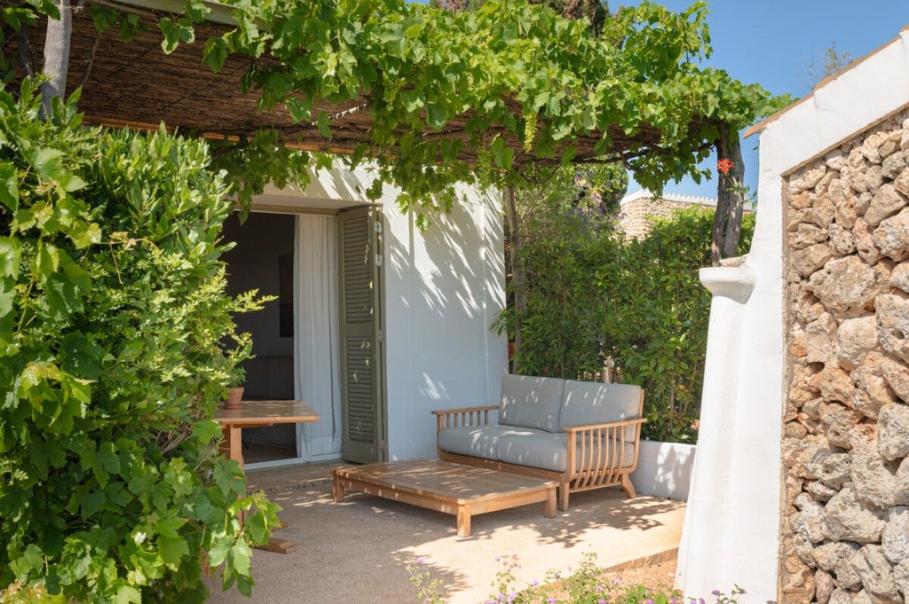 Elegant whitewashed Spanish coastal hotel room with minimalist design, crisp linens, and panoramic azure Mediterranean Sea view through large windows