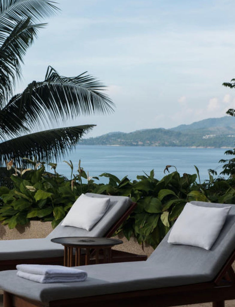 Modern luxury pavilion suite overlooking private infinity pool with ocean views from elevated hillside, featuring Thai architectural elements