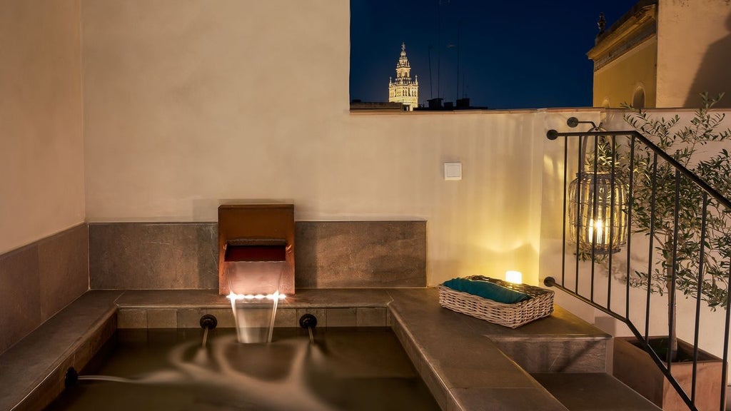 Elegant Spanish boutique hotel with white stone facade, wrought iron balconies, arched windows and traditional Andalusian architecture