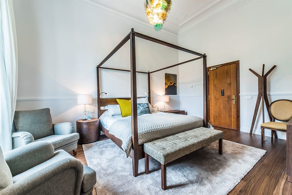 Elegant double room at scenset hotel, featuring plush white bedding, minimalist design, and warm wooden accents with soft natural lighting from large windows