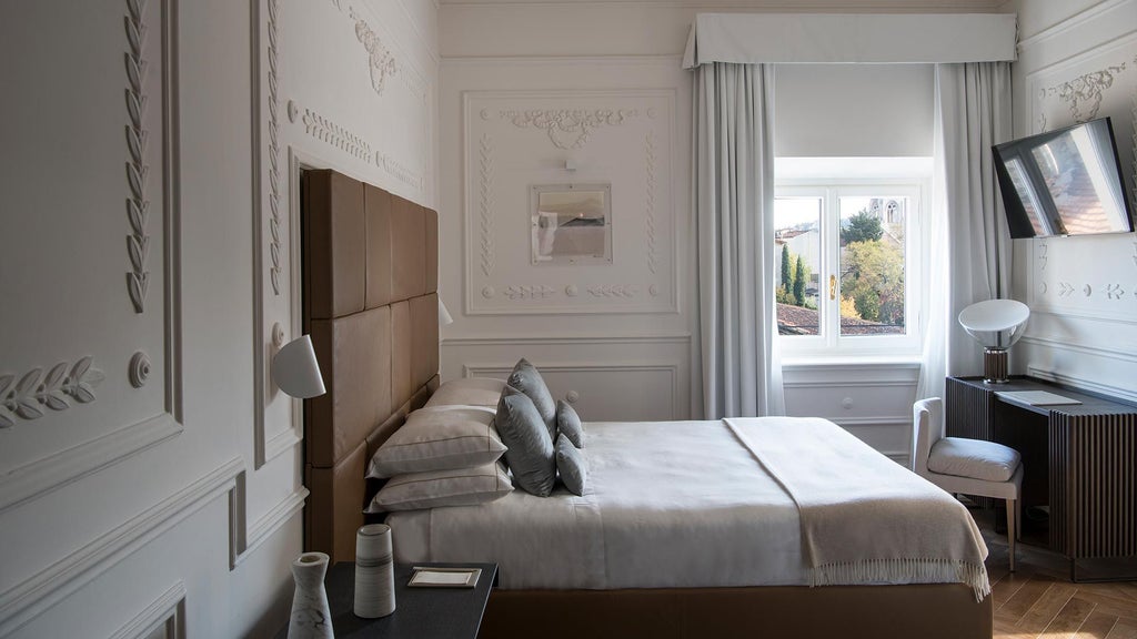 Elegant Superior room at Dimora Palanca, featuring plush white bedding, soft neutral tones, artisan wooden furniture, and large windows overlooking Italian landscape