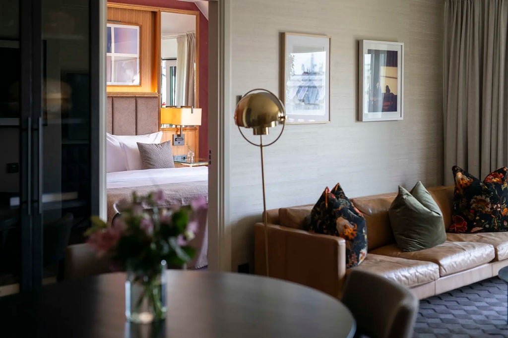 Luxurious minimalist hotel room with crisp white linens, sleek dark wooden furnishings, and large windows offering soft natural light in Swedish design