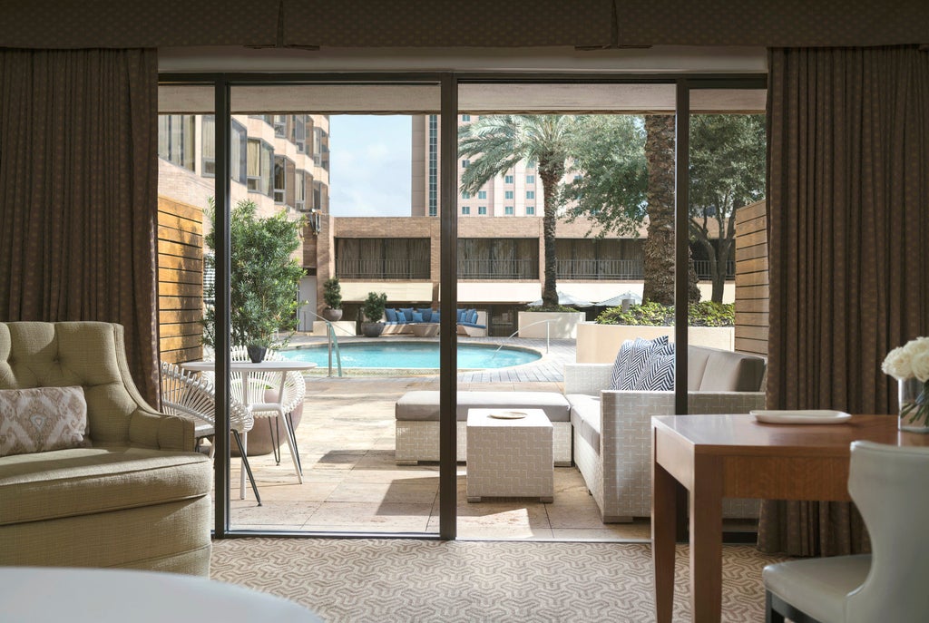 Elegant Four Seasons hotel exterior in downtown Houston featuring modern glass facade, circular driveway, and grand entrance with valet service