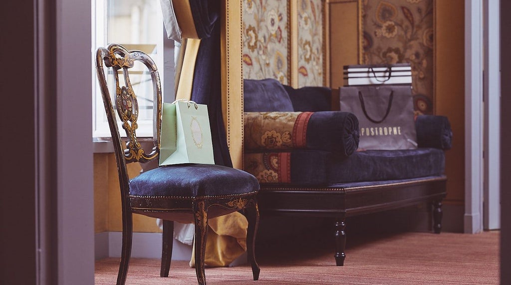 Elegant French luxury suite with plush king bed, marble bathroom, city view window, and soft neutral color palette in a refined boutique hotel room