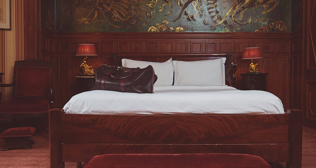 Elegant French hotel suite with plush velvet armchairs, ornate golden mirrors, and rich burgundy accents inspired by Oscar Wilde's sophisticated aesthetic