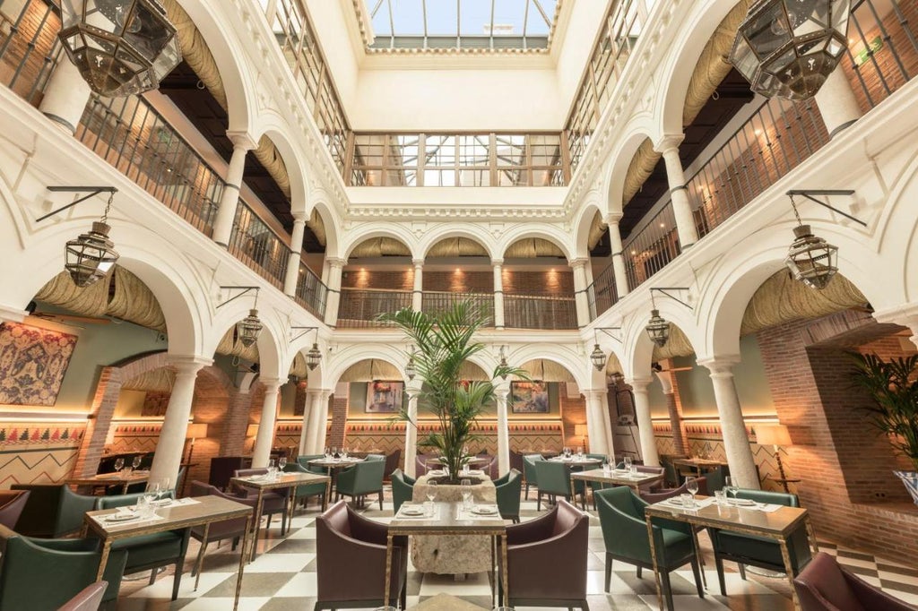 Elegant stone facade of Palacio Solecio hotel with classic Spanish balconies, ornate columns and grand entrance with brass lanterns